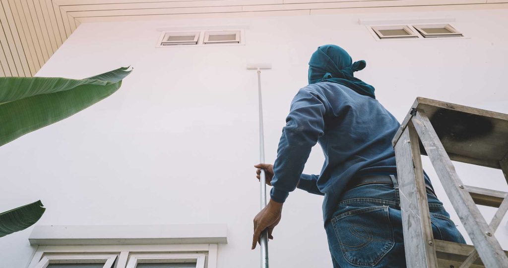 The expert painter works on a residential exterior painting project