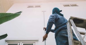 The expert painter works on a residential exterior painting project